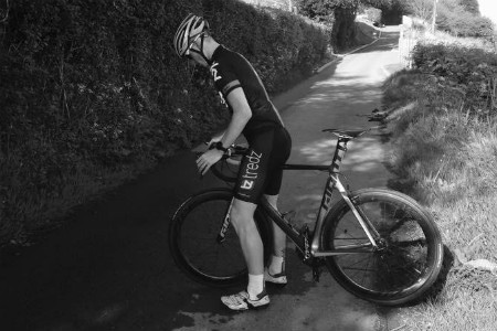 Monochromatic photo of Ieuan next to his bike 